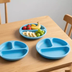 Blue silicone toddler plates with fruit on wooden table
