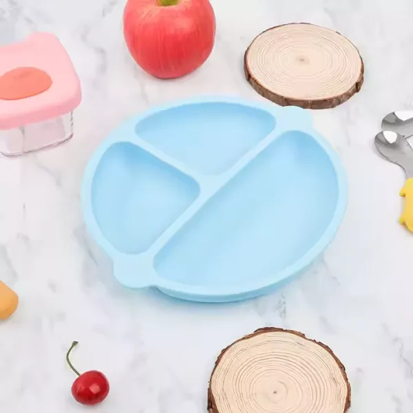 Light blue silicone baby suction plate with three compartments on marble surface