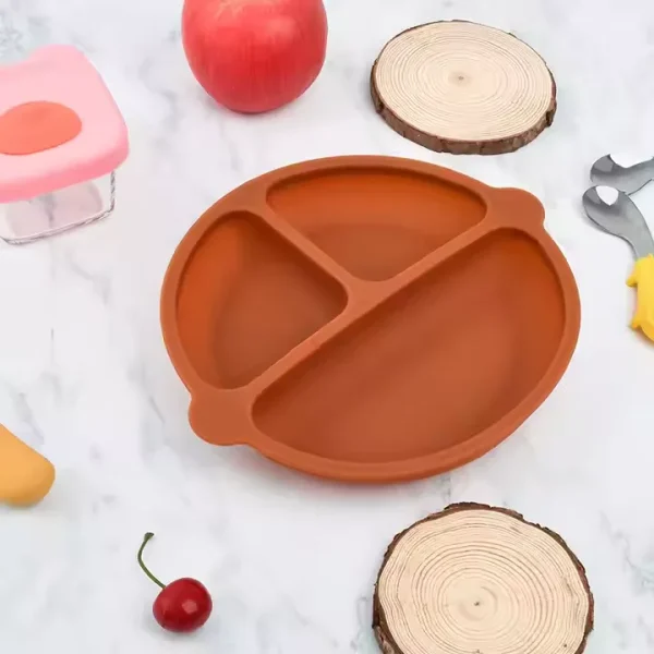 Orange silicone suction plate with three compartments on marble background