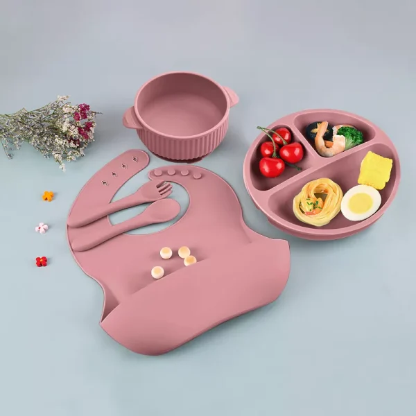 Dusty pink silicone baby feeding set with bib, bowl, utensils, and divided plate