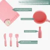 Pink silicone cookware play set with pot, pan, utensils, and bottle.