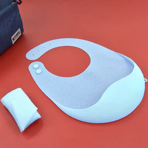 Light blue silicone baby bib on a red background.