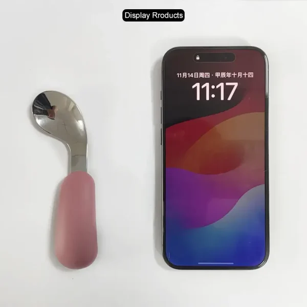Baby Spoon and Phone Size Display Baby spoon placed next to smartphone for scale reference.