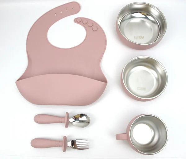 Dusty Pink Toddler Feeding Set Dusty pink toddler meal kit with bib, bowl, cup, spoon, and fork.